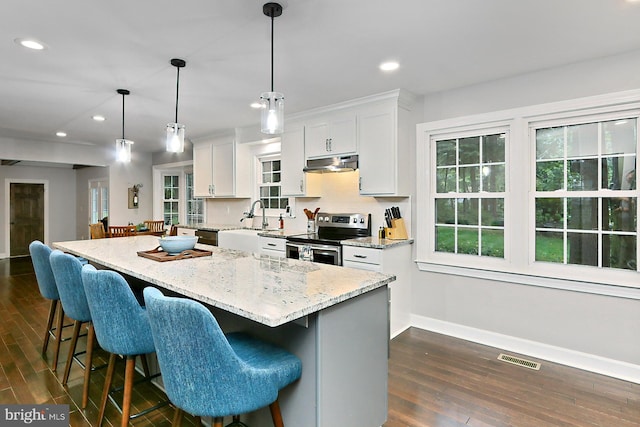 kitchen featuring white cabinetry, electric stove, dark hardwood / wood-style flooring, a center island, and decorative light fixtures