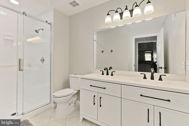 bathroom featuring tile patterned flooring, a shower with door, toilet, and vanity