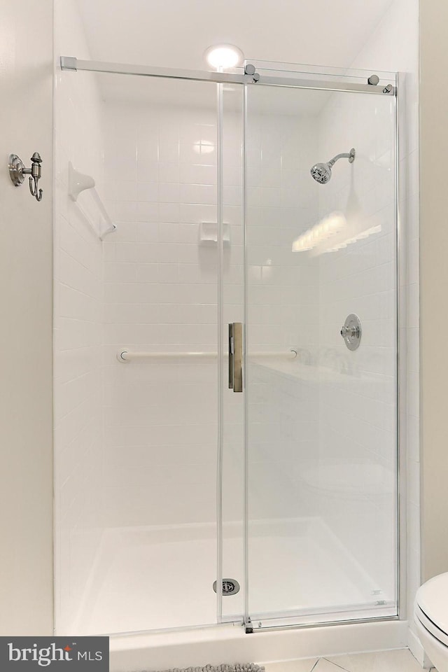 bathroom featuring toilet and an enclosed shower