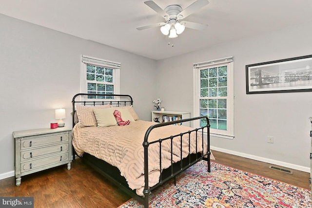 bedroom with multiple windows, dark hardwood / wood-style floors, and ceiling fan