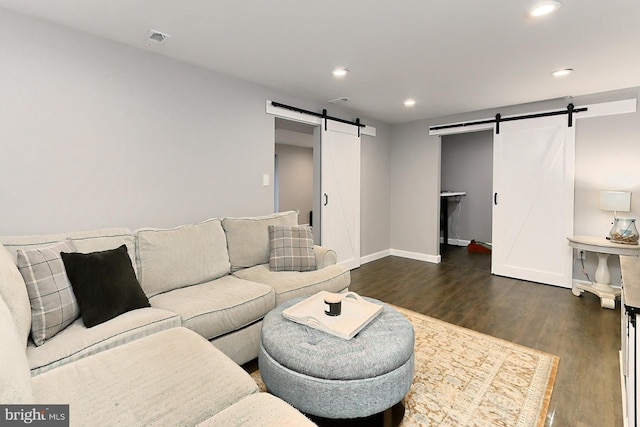 living room with dark hardwood / wood-style floors and a barn door