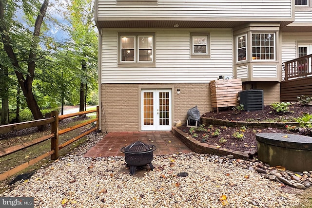 rear view of house with a patio, cooling unit, and a fire pit