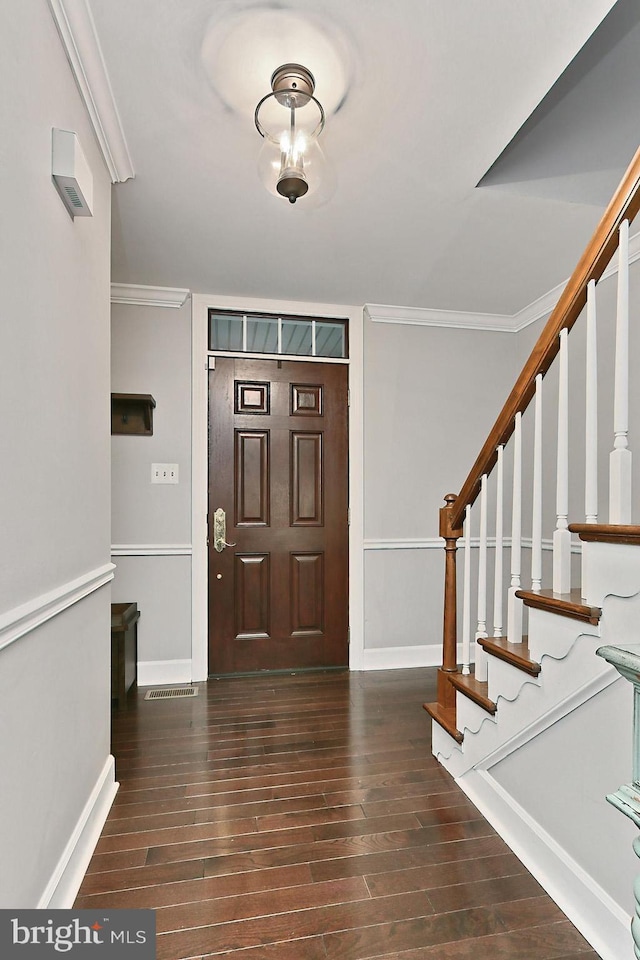 foyer featuring crown molding and dark hardwood / wood-style flooring