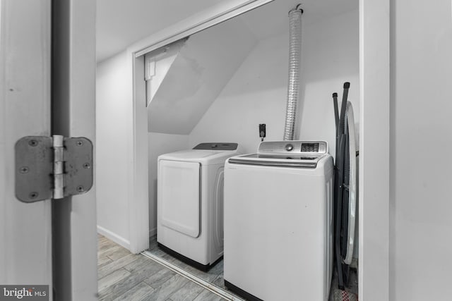 washroom with washing machine and dryer and light hardwood / wood-style floors