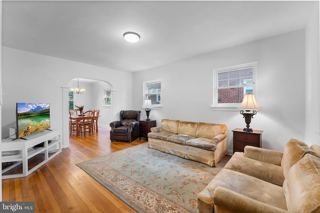 living room featuring plenty of natural light, a chandelier, and light hardwood / wood-style floors