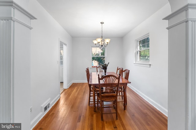 dining space featuring wood-type flooring and a chandelier