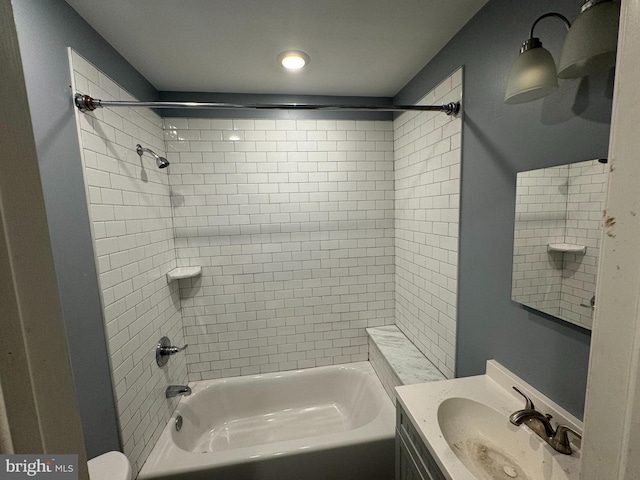 bathroom featuring tiled shower / bath and vanity