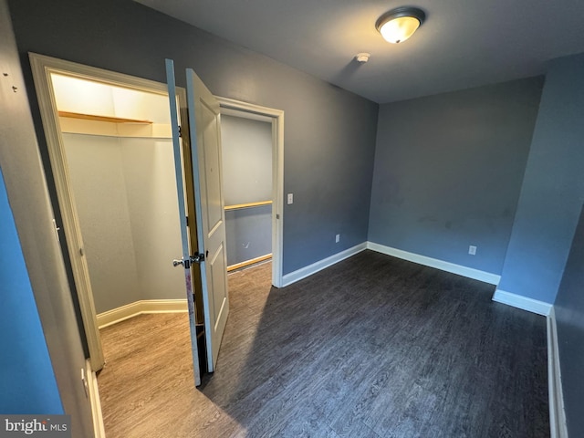 unfurnished bedroom with a closet and wood-type flooring