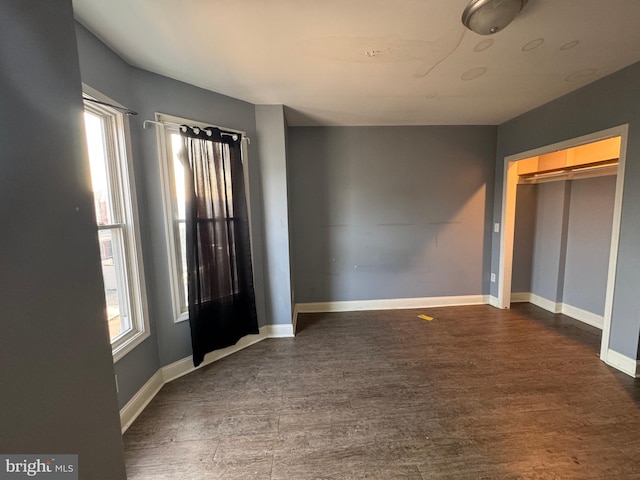 spare room featuring a healthy amount of sunlight and dark hardwood / wood-style floors