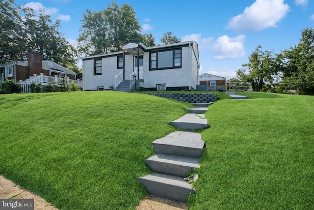 view of front of house featuring brick siding and a front lawn