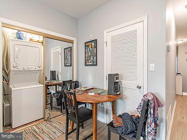 dining room featuring light wood-type flooring and stacked washer and clothes dryer