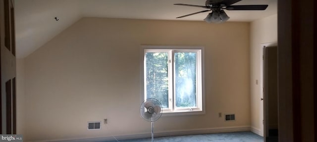 empty room featuring a healthy amount of sunlight, vaulted ceiling, and ceiling fan