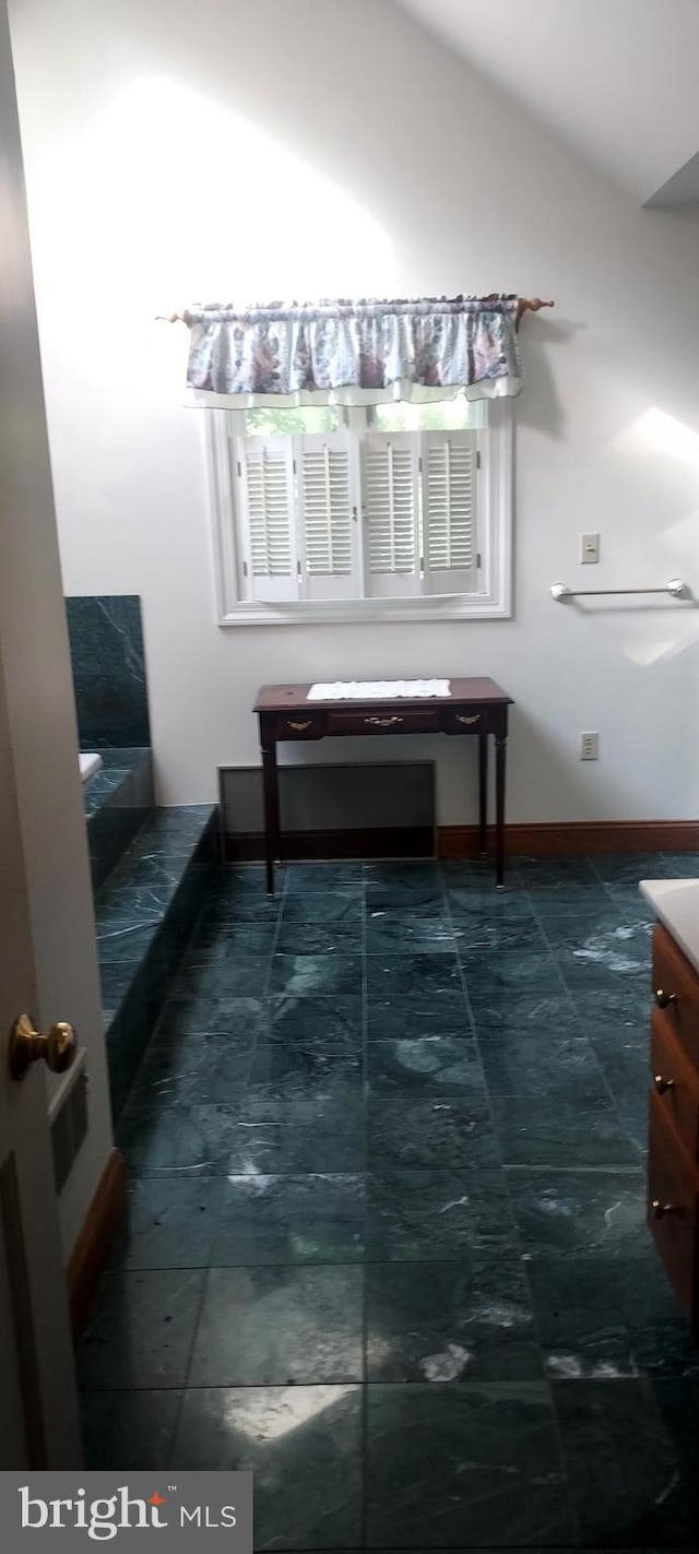 bathroom featuring vaulted ceiling and vanity