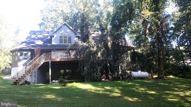 rear view of house featuring a deck and a yard