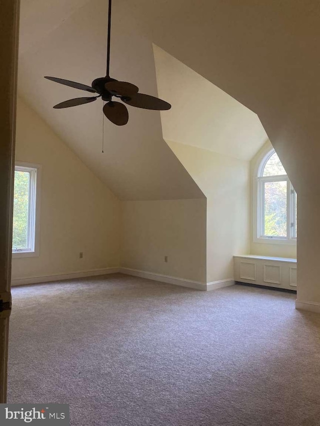 bonus room with vaulted ceiling, ceiling fan, and light colored carpet