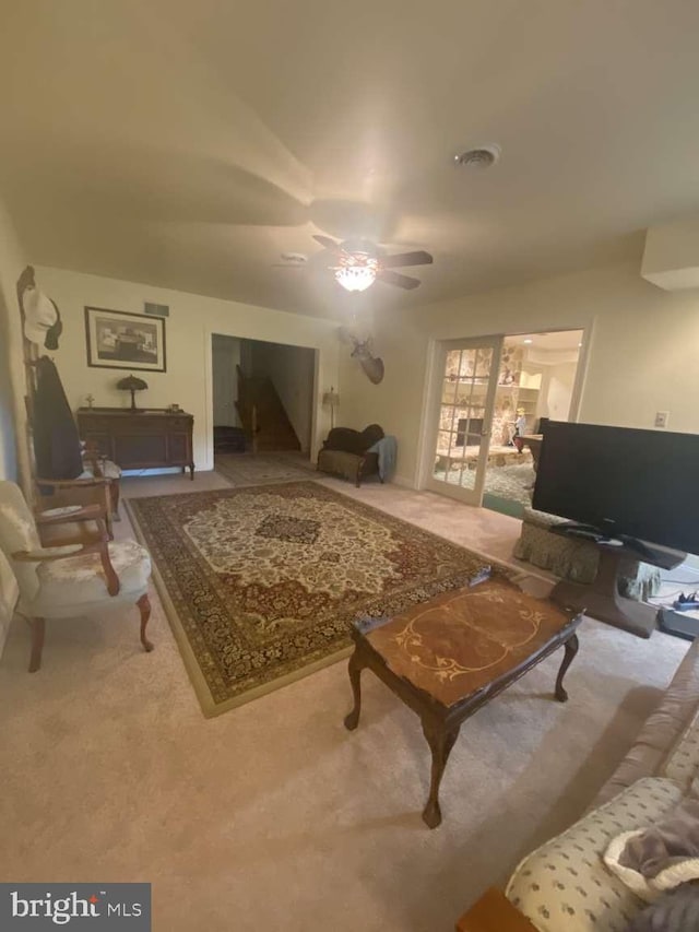 carpeted living room with ceiling fan