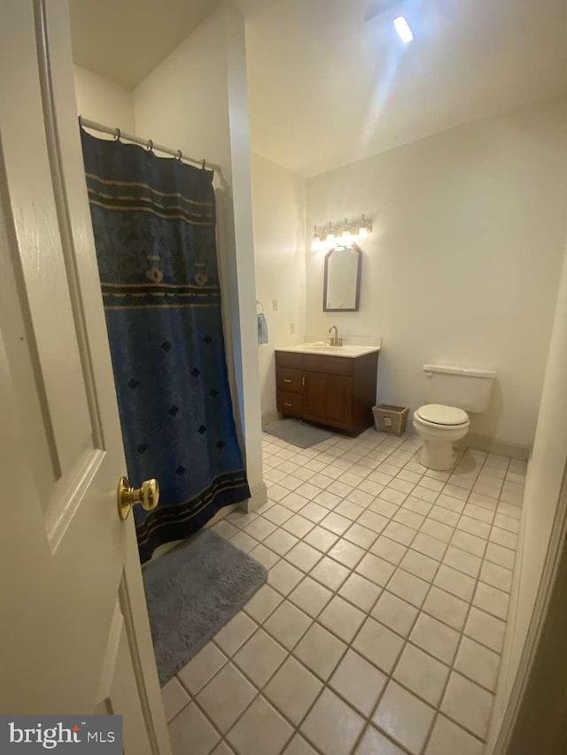 bathroom with a shower with curtain, vanity, tile patterned flooring, and toilet