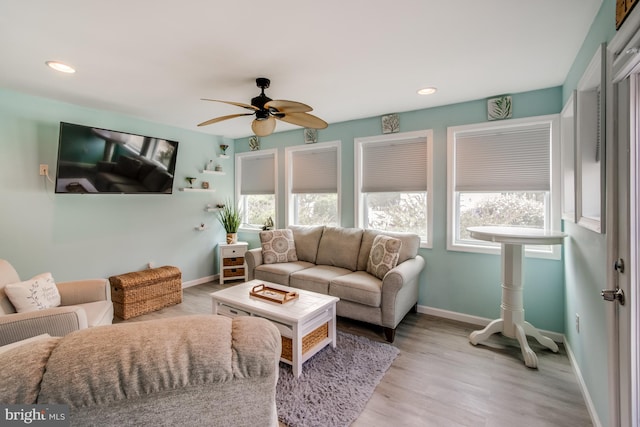 living room with light hardwood / wood-style flooring and ceiling fan