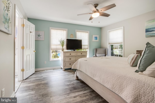 bedroom with multiple windows, ceiling fan, and hardwood / wood-style flooring