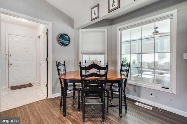 dining space with vaulted ceiling, dark hardwood / wood-style flooring, and ceiling fan