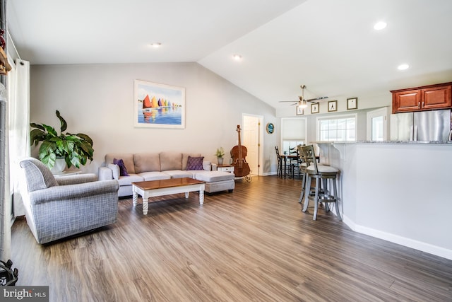 living room with dark wood-type flooring, ceiling fan, and lofted ceiling