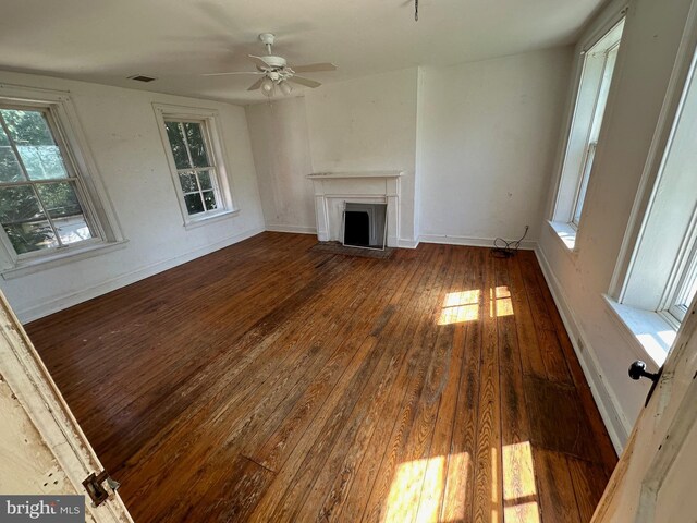 unfurnished living room featuring a fireplace, wood finished floors, visible vents, and baseboards