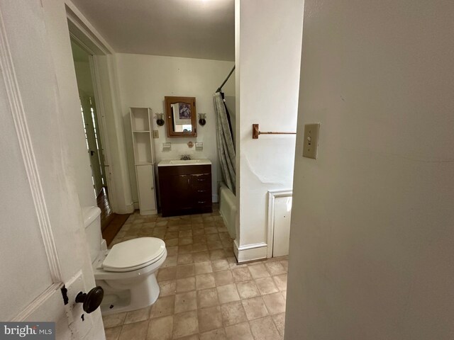 bathroom featuring vanity, toilet, and shower / tub combo with curtain