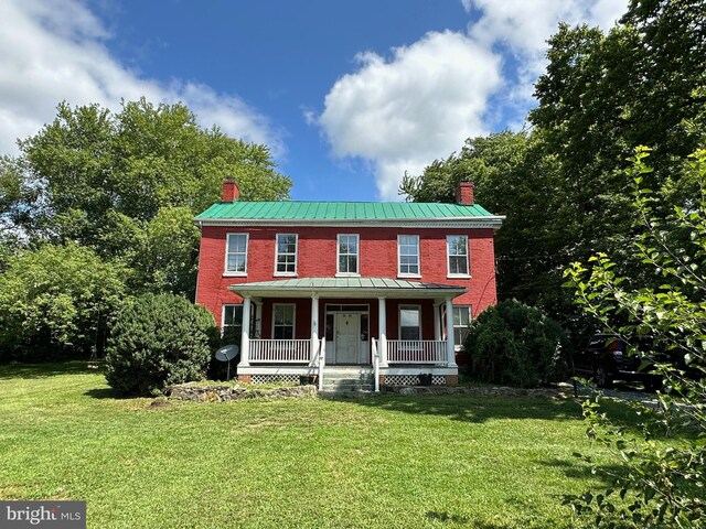 colonial house featuring a front yard and a porch