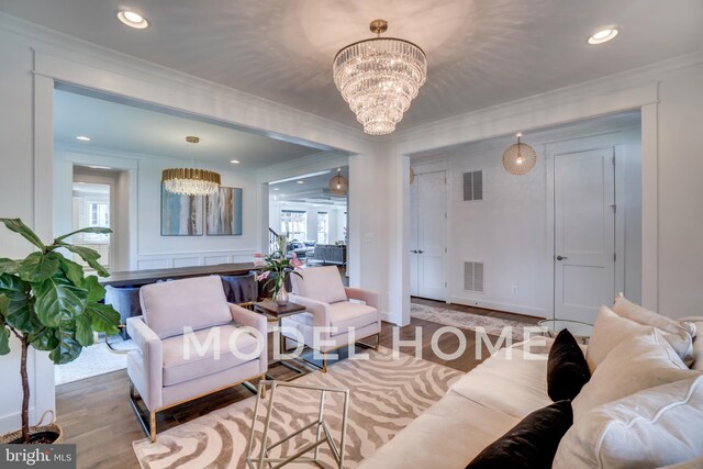 living room featuring a notable chandelier, crown molding, and hardwood / wood-style floors