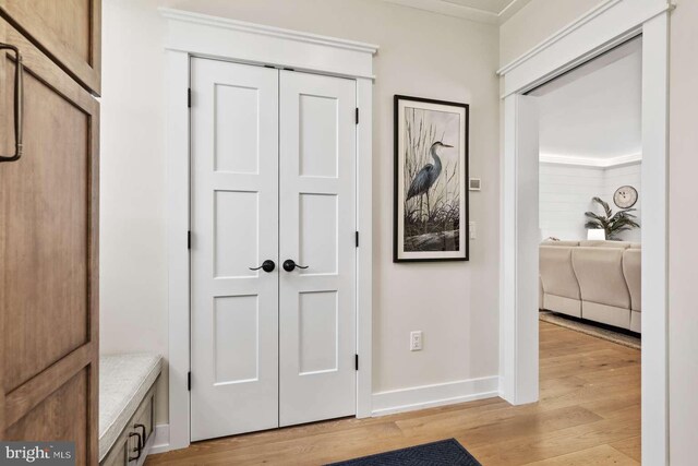 interior space featuring light wood-type flooring and crown molding