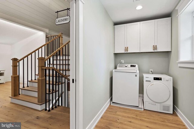 washroom featuring light hardwood / wood-style floors, separate washer and dryer, and cabinets