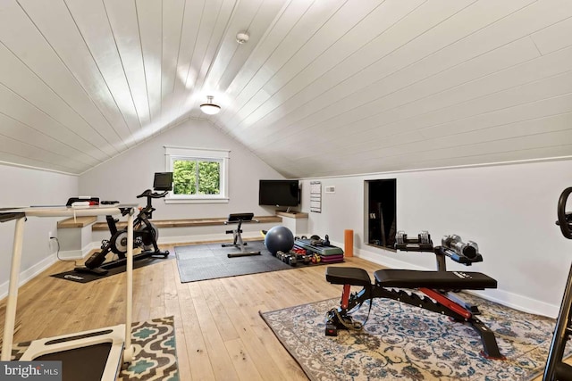 exercise room featuring wood ceiling, light hardwood / wood-style flooring, and lofted ceiling