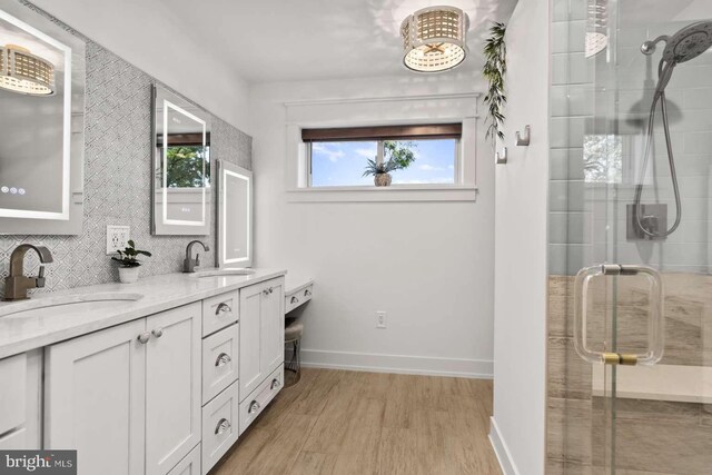 bathroom with hardwood / wood-style flooring, vanity, and a shower with shower door