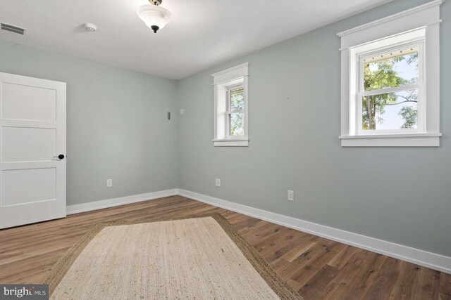 unfurnished room with a healthy amount of sunlight and wood-type flooring