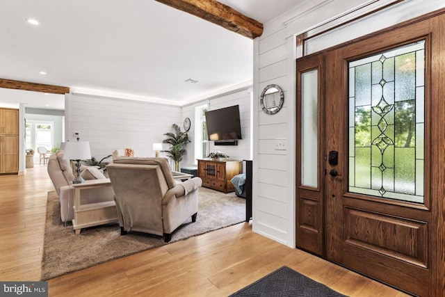 entrance foyer with light hardwood / wood-style flooring, beamed ceiling, and a healthy amount of sunlight