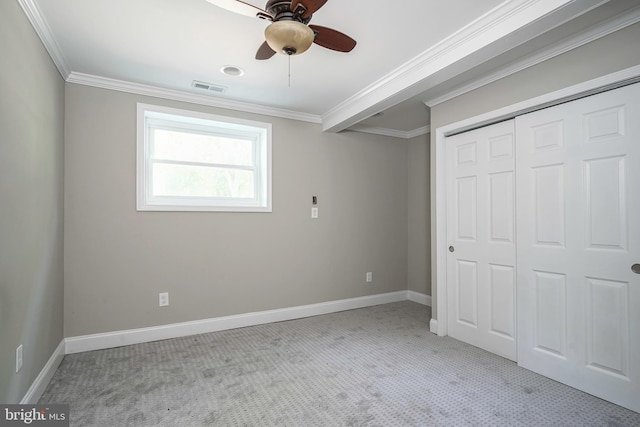 unfurnished bedroom with a closet, ceiling fan, crown molding, and light colored carpet