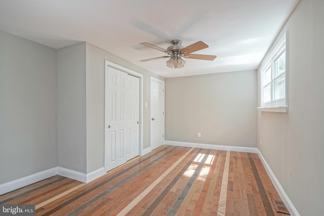 unfurnished bedroom with ceiling fan and hardwood / wood-style flooring