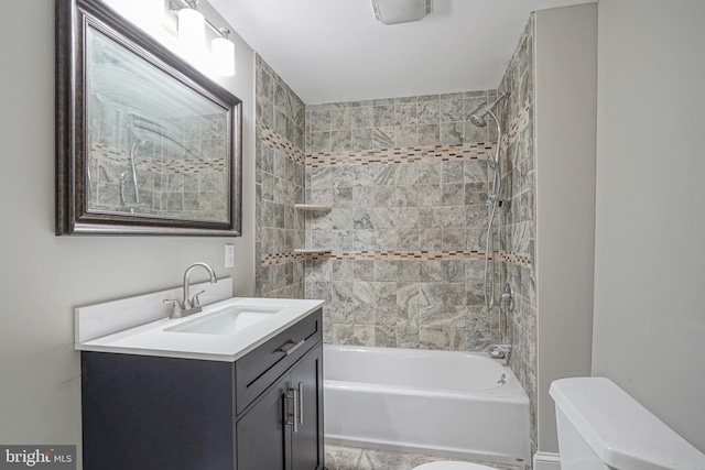 full bathroom featuring tiled shower / bath combo, toilet, and vanity