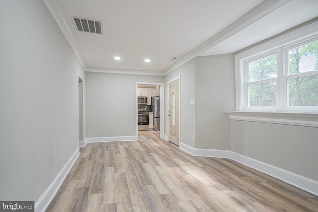 spare room with light wood-type flooring and ornamental molding