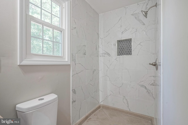 bathroom with tiled shower and toilet