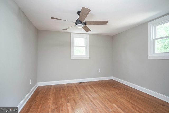 spare room featuring ceiling fan, light hardwood / wood-style floors, and a healthy amount of sunlight