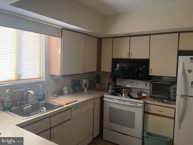 kitchen with decorative backsplash, white appliances, and sink