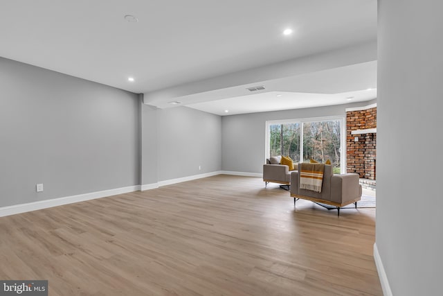 sitting room with a fireplace and light wood-type flooring