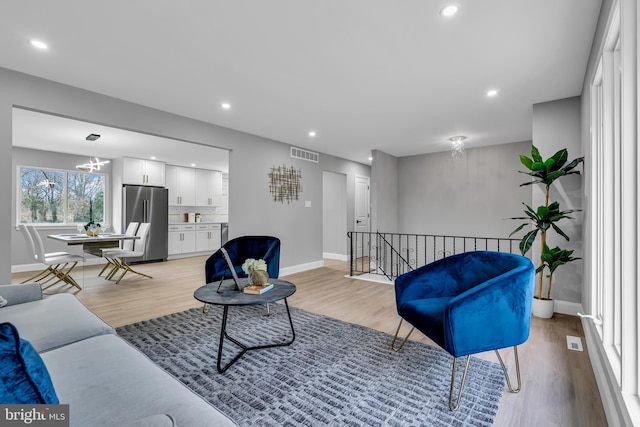 living room featuring a notable chandelier and light wood-type flooring