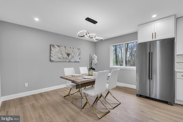 dining space with an inviting chandelier and light hardwood / wood-style floors