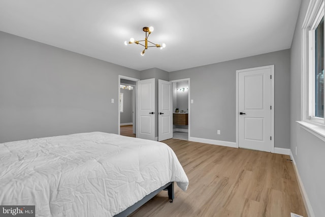 bedroom featuring light wood-type flooring and a notable chandelier