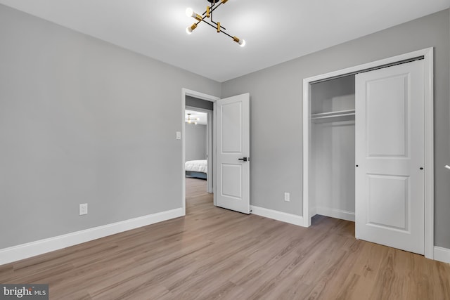 unfurnished bedroom with light wood-type flooring and a closet