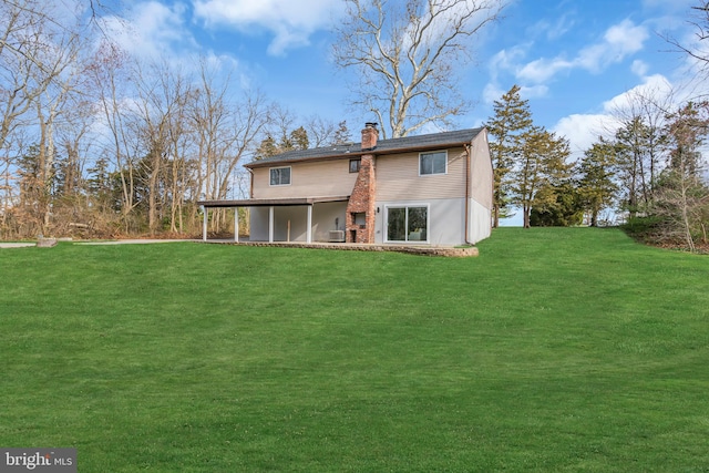 rear view of house featuring a yard