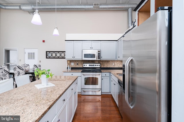 kitchen with tasteful backsplash, dark wood-style floors, visible vents, appliances with stainless steel finishes, and pendant lighting