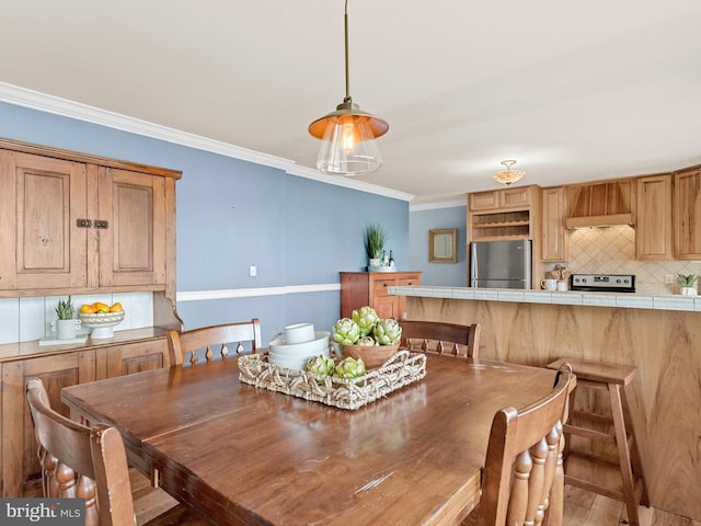 dining room featuring ornamental molding and light wood-type flooring